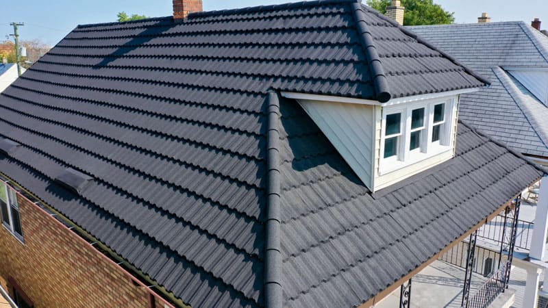 A view of a grey house with metal roof