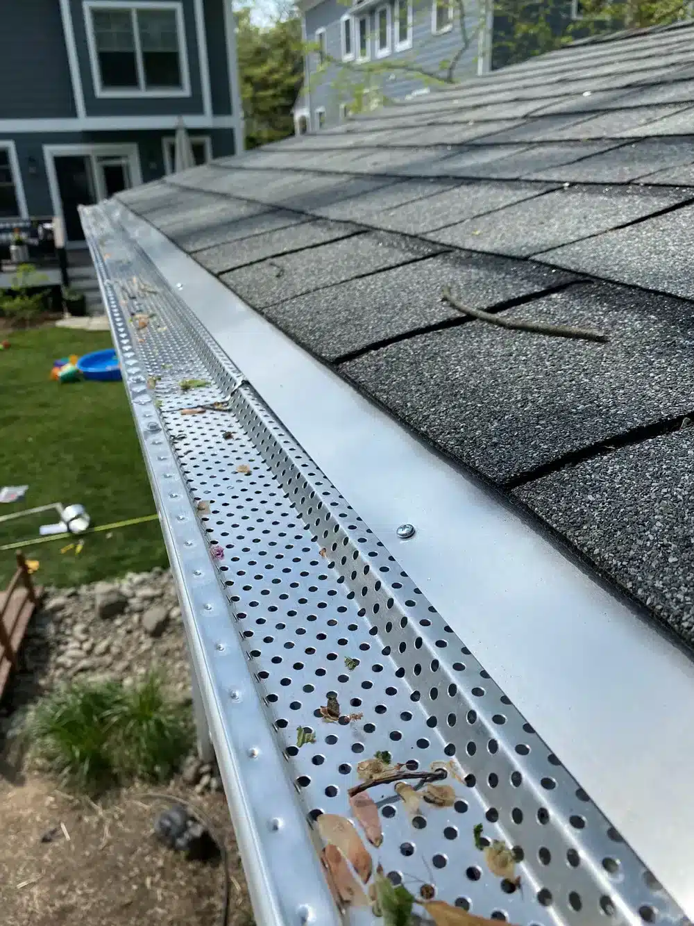 A view of a hand taking out the old roof drip edge