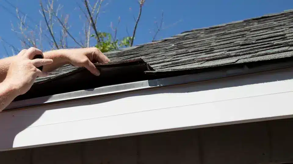 A view of a person holding a roof panel to inspect