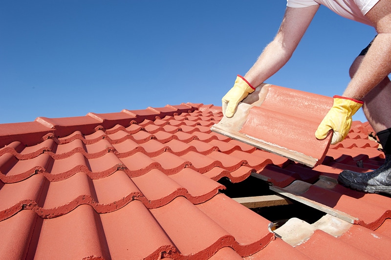 A view of a person taking out a red brick roofing