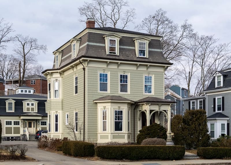 A view of a white house with mansard roof