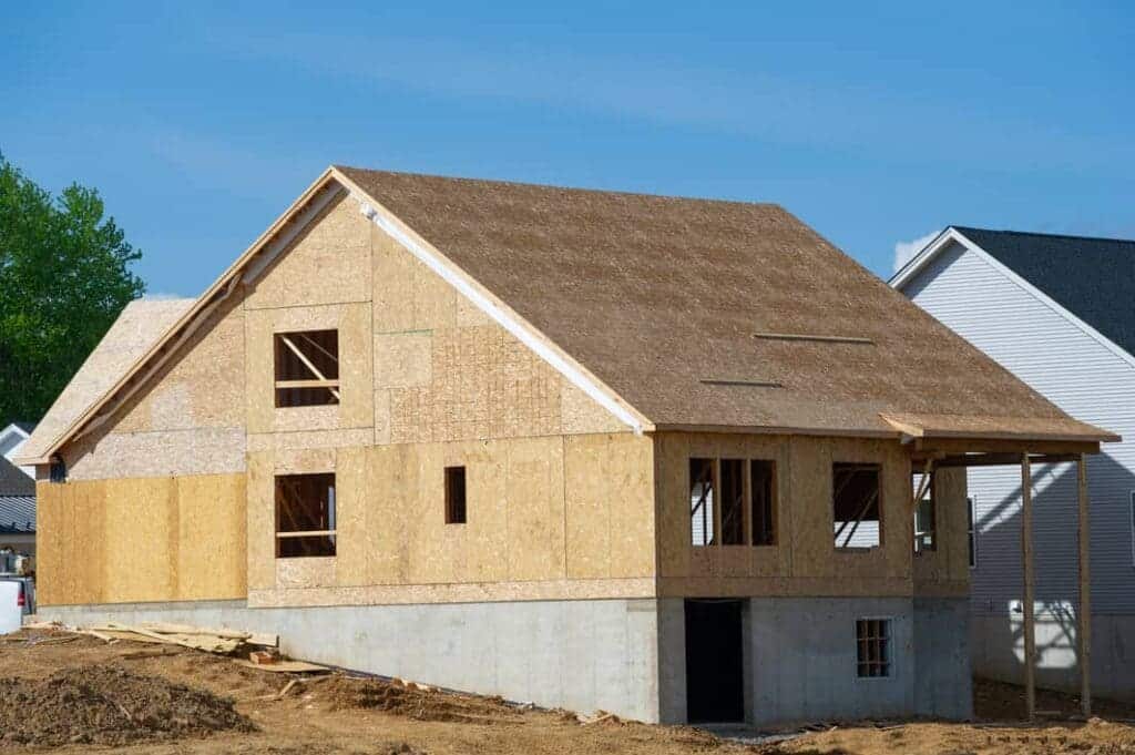 A view of a wooden house under construction with wood sheathing