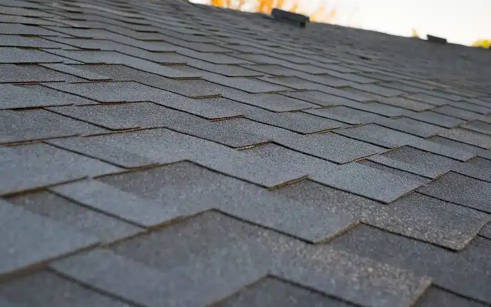 A view of grey asphalt shingles on a roof of house