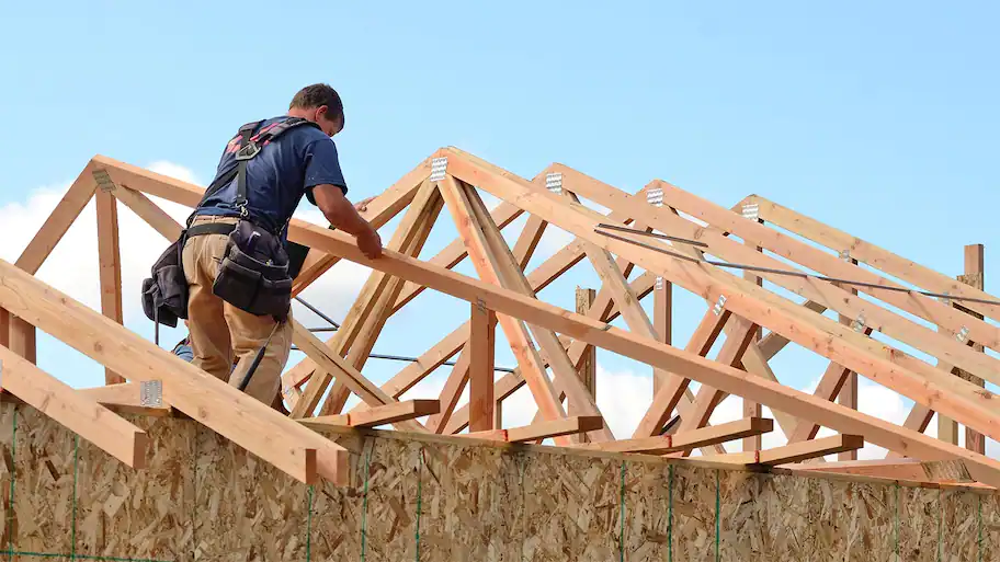 a man working on half constructed shed roof