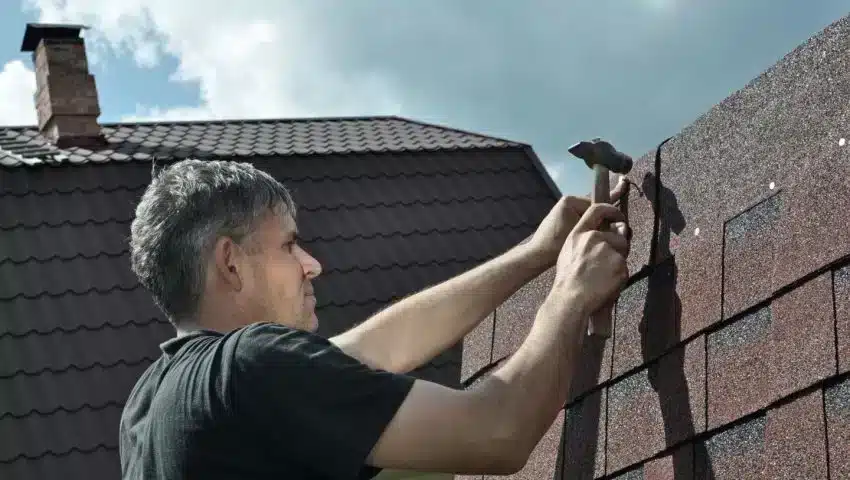 a person repairing the roof with a hammer