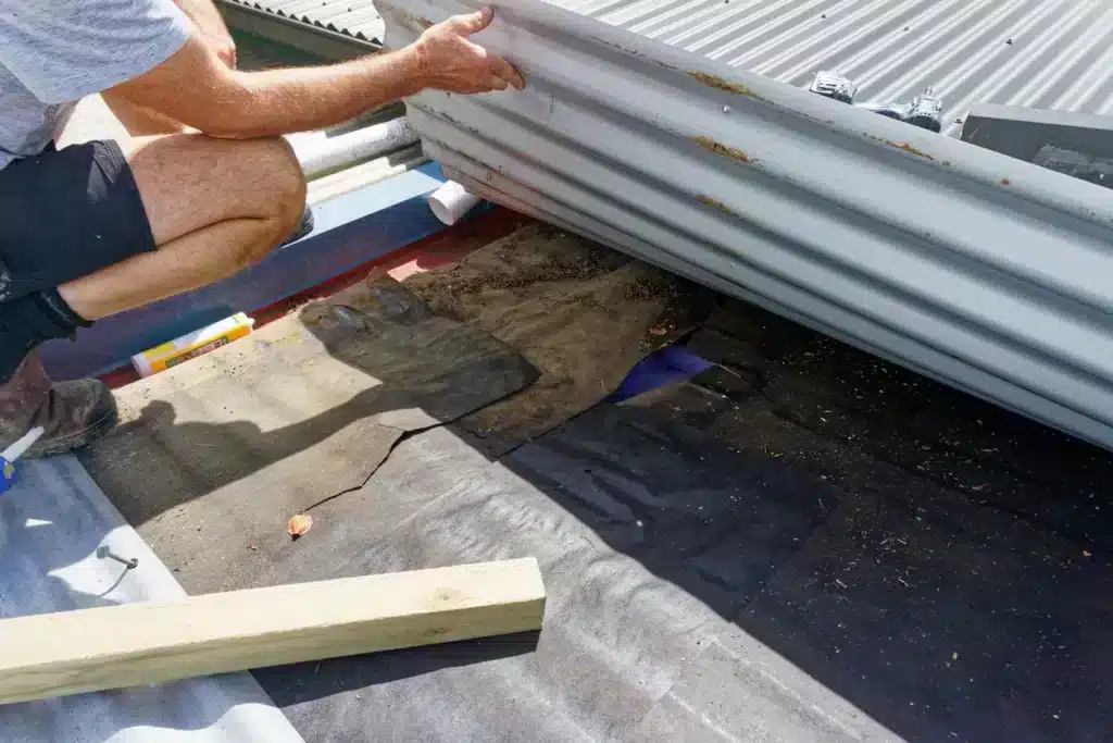 zoomed in view of male hands working on a flat roof