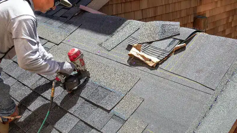 a person installing roofing shingles