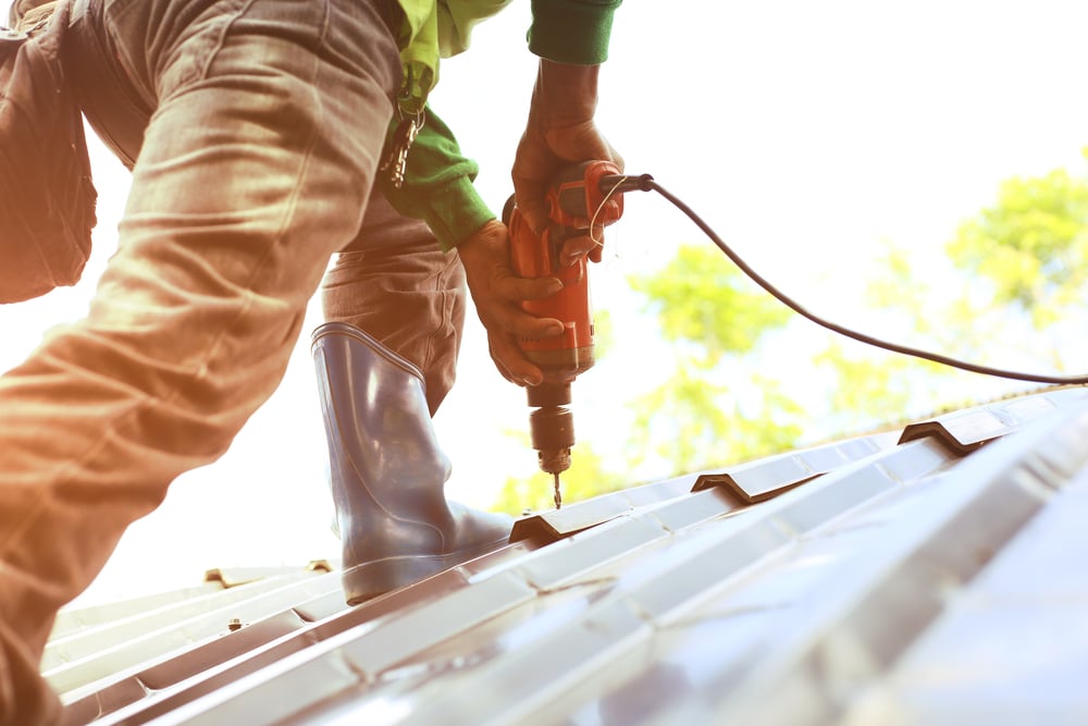 close up of hands installing metal roofs