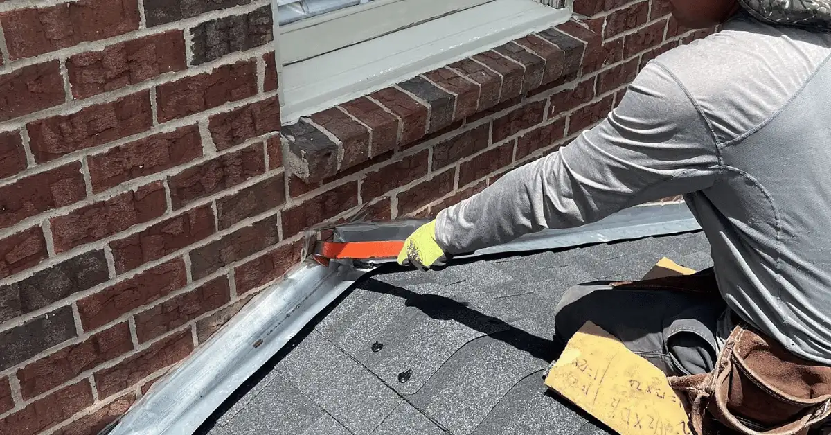 Roofing professional applying flashing around a chimney to prevent leaks Roofing professional applying flashing around a chimney to prevent leaks