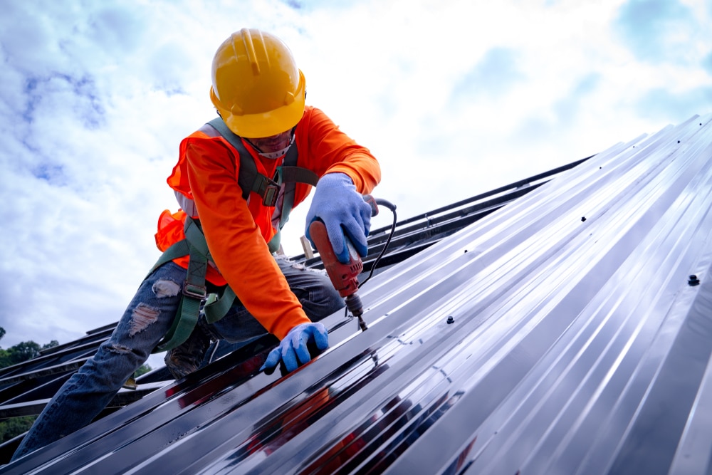 a contractor installing roof panels a contractor installing roof panels