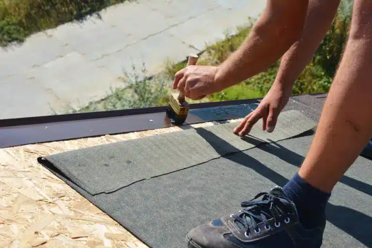 zoomed view of a roofing contractor hands wokring on underlayment x zoomed view of a roofing contractor hands wokring on underlayment x